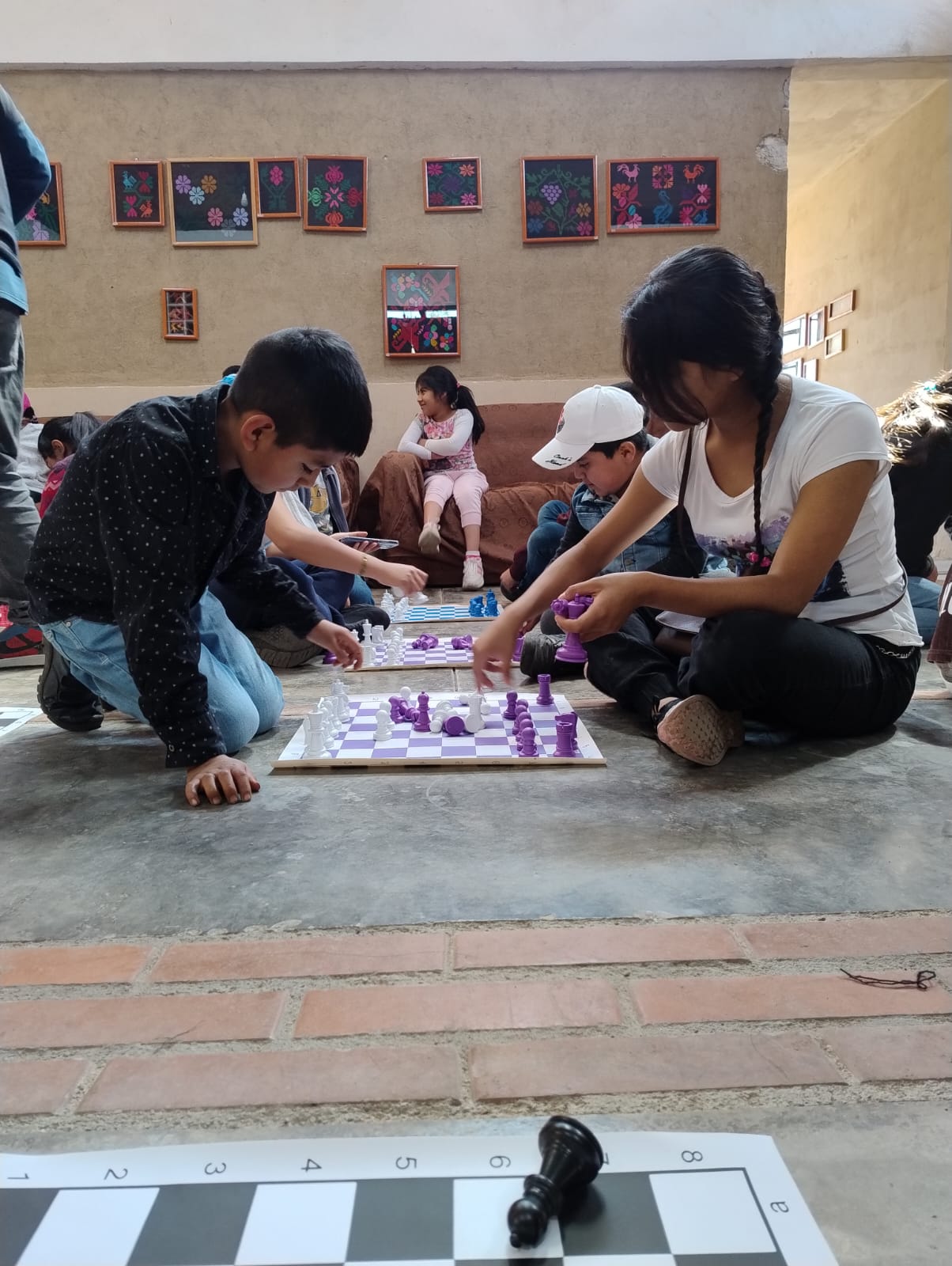 Niñas y niños juegan ajedrez durante un taller en Hueyapan